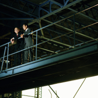 2 trabajadores en traje hablando en una plataforma.