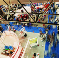 Vista desde arriba de una feria comercial llena de gente.