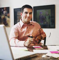 hombre sonriendo sentado en el escritorio de su casa.