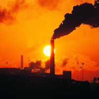 Imagen de una industria petrolífera en un atardecer.