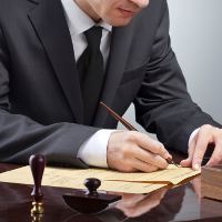 Un hombre con traje oscuro firmando un documento.