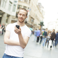 Un joven usando su smartphone en la calle.
