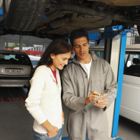 Un mecánico de coches explicando la reparación a una clienta.