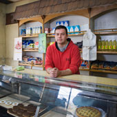 Emprendedor en apoyado en el mostrador de su tienda.