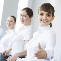 3 mujeres vestidas de blanco sonriendo con el pulgar hacia arriba.