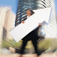 Hombre en traje sosteniendo una flecha en dirección ascendente.