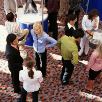 Vendedores charlando con clientes en una feria comercial.